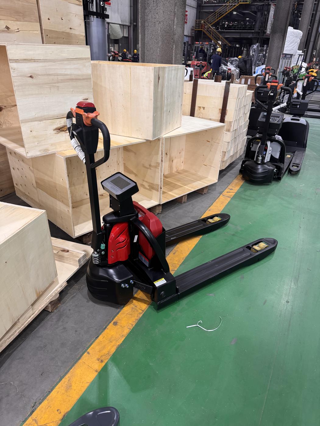 Accelift electric pallet truck next to plywood shipping crates