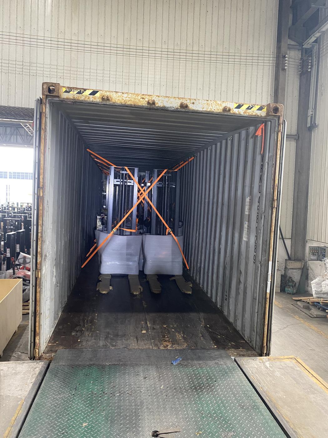 Two electric stackers strapped at the far end of a 40HQ container