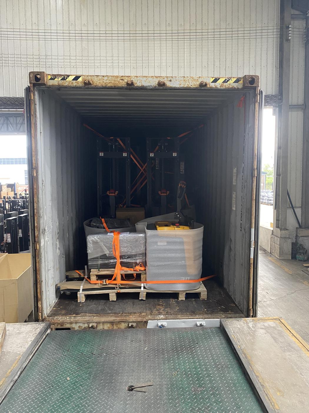 Palletised units held with orange ratchet straps inside the container